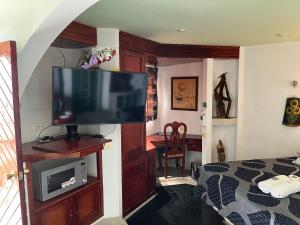 a bedroom with a flat screen tv on a entertainment center at Hotel Las Flores in Xalapa