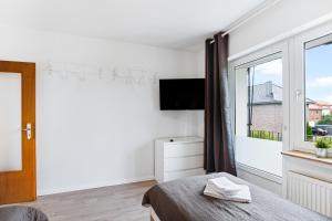 ein weißes Schlafzimmer mit einem Bett und einem Fenster in der Unterkunft Schöne Wohnung in Geseke in Niederdorla