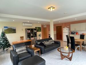 a living room with black furniture and a christmas tree at Christiana Apartment Morne Daniel in Canefield +17 photos