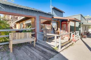 a house with a wooden porch with a bench at Walk to Main Street! Mtn-View Getaway in Pioche in Pioche