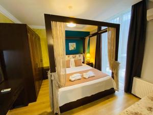 ein Schlafzimmer mit einem Himmelbett und Handtüchern darauf in der Unterkunft Royal Loft Suit in Antalya + 106 Fotos