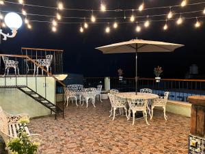 a patio with a table and chairs and an umbrella at Hotel Las Flores in Xalapa