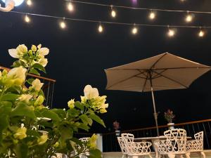 a patio with an umbrella and chairs and lights at Hotel Las Flores in Xalapa