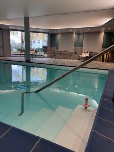 a swimming pool with a red object in the water at Domitys Les Châtaigniers in Panazol