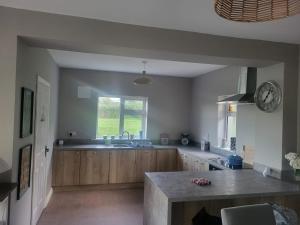 a kitchen with a sink and a clock on the wall at Sunny south east in Wexford in Blackwater