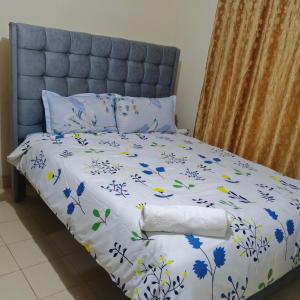 GituraJanesuites kenol的一张带蓝色和白色床单的床,上面有鲜花