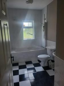 a bathroom with a tub and a toilet and a window at Sunny south east in Wexford in Blackwater +9 photos