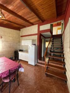 een keuken met een trap met een tafel en een koelkast bij Cabañas El Pela in Villa Carlos Paz