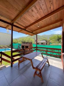 een houten patio met een tafel en banken op een terras bij Cabañas El Pela in Villa Carlos Paz +17 foto's