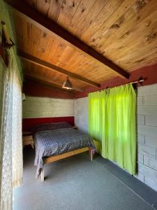 a bedroom with a bed with a green curtain at Cabañas El Pela in Villa Carlos Paz +17 photos