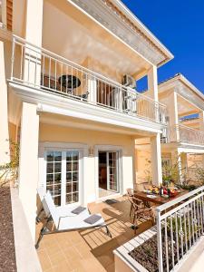 una casa con balcone, tavolo e sedie di Balaia Poolside House with Sea View by BeCherish a Branqueira