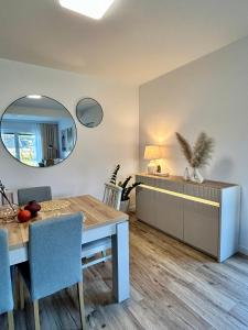 Łeba Garden Apartament في ليبا: غرفة طعام مع طاولة ومرآة