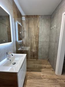 a bathroom with a white sink and a shower at Łeba Garden Apartament in Łeba +28 photos