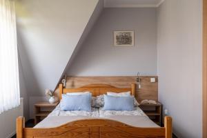 Willa Widok في بوكافينا تترايسكا: غرفة نوم مع سرير خشبي مع وسائد زرقاء