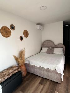 Alto Paraiso Glamping "A" في Carmen de Viboral: غرفة نوم بسرير وبعض السلال على الحائط +23 صورة