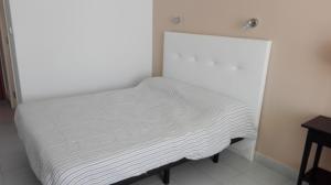 Una cama blanca en una habitación con una mesa. en Apartamento Tobago, en Puerto Rico de Gran Canaria 19 fotos más