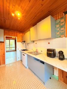 a kitchen with white counter tops and wooden ceilings at Positive country in Aulnay-sous-Bois