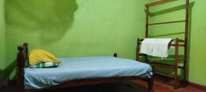 Habitación pequeña con cama y escalera en Sinharaja Tour Guide, en Nikawatawana