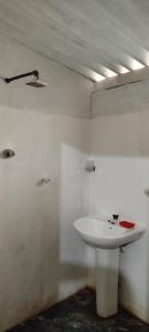 Un baño con un lavabo blanco en una habitación. en Sinharaja Tour Guide, en Nikawatawana