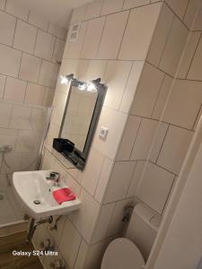 Un baño con lavabo, inodoro y espejo. en Wohnung in maintal, en Maintal