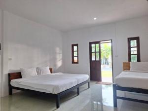two beds in a room with white walls at Lanta Mother House in Ko Lanta +83 photos