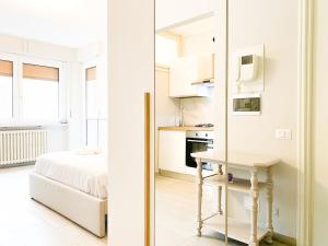 um quarto branco com uma cama e uma mesa em Comfort Studio - Design Moderno & Free Parking em Chiusa di Pesio