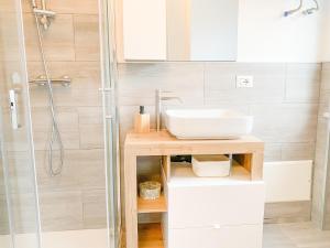 um banheiro com pia e chuveiro em Comfort Studio - Design Moderno & Free Parking em Chiusa di Pesio