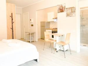 um quarto branco com uma mesa e cadeiras brancas em Comfort Studio - Design Moderno & Free Parking em Chiusa di Pesio mais 6 fotografias