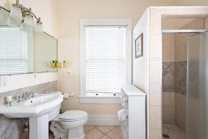 a white bathroom with a sink and a toilet at Curry House - Rooms 3 & 4 in Key West
