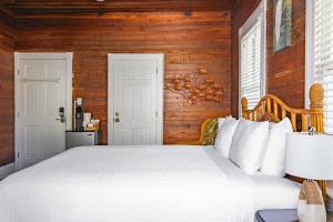 a bedroom with a white bed and wooden walls at Curry House - Rooms 3 & 4 in Key West