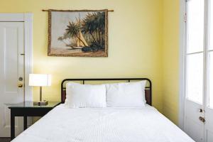 a bedroom with a bed and a picture on the wall at Curry House - Rooms 3 & 4 in Key West +9 photos
