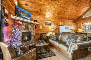 a living room with a fireplace and a christmas tree at Tranquil View by American Patriot Getaways in Glade