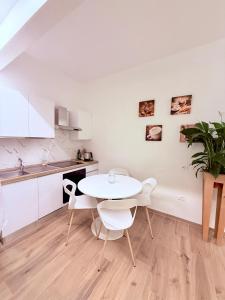 une cuisine blanche avec une table et des chaises blanches dans l'établissement Ama Esclusive Spa Florence, à Florence
