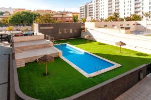 eine Draufsicht auf einen Swimmingpool auf einem Gebäude in der Unterkunft Palm Suites Gran Vía in Alicante