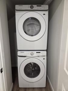 a washing machine and a dryer in a room at The Heavenly Crib in Saskatoon +2 photos