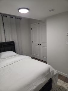 a bedroom with a white bed and a white closet at The Heavenly Crib in Saskatoon
