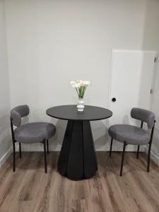 a table with two chairs and a vase with flowers on it at The Heavenly Crib in Saskatoon