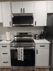 a kitchen with a stove and a microwave at The Heavenly Crib in Saskatoon
