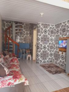 a room with a bed and a tv on a wall at Sobrados pertinho do mar in Tramandaí