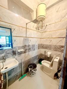 リシケーシュにあるThe Anand By The Gangesのバスルーム(トイレ、シンク、照明付)