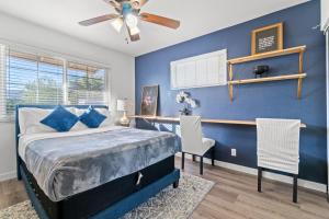 een blauwe slaapkamer met een bed en een plafondventilator bij Pool & Fire Pits • Pet Friendly • 3 BR Home in Las Vegas +22 foto's