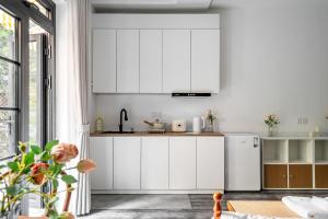 a kitchen with white cabinets and a white refrigerator at Changle Road in Shanghai