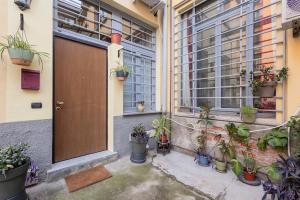un ingresso di un edificio con un mucchio di piante in vaso di Living Bovisa a Milano