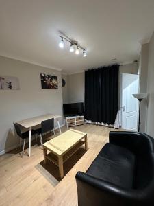 una sala de estar con un sofá y una mesa en Workers & Families Home- Close to Transport & Town, en Porth