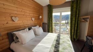 a bedroom with a bed with a wooden wall at Annexe by Hôtel La Réserve in Gérardmer +20 photos