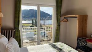 a bedroom with a bed and a view of a balcony at Annexe by Hôtel La Réserve in Gérardmer