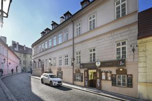 una macchina bianca parcheggiata di fronte a un edificio di White Swan Boutique Apartments a Praga