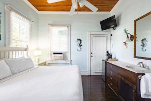a bedroom with a bed and a sink and a mirror at Curry House - Room 5 in Key West