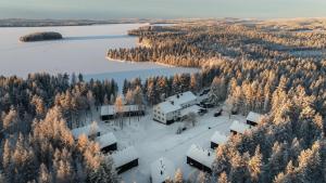 an aerial view of a house in the snow next to a lake at Skýra Retreat in Rovaniemi