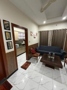 een woonkamer met een blauwe bank en een tafel bij kohistan Enclave wah cantt 